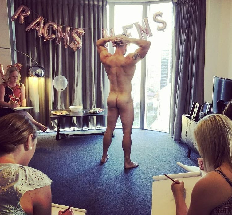 The life drawing model posing from behind under rose gold balloons while hens sketch