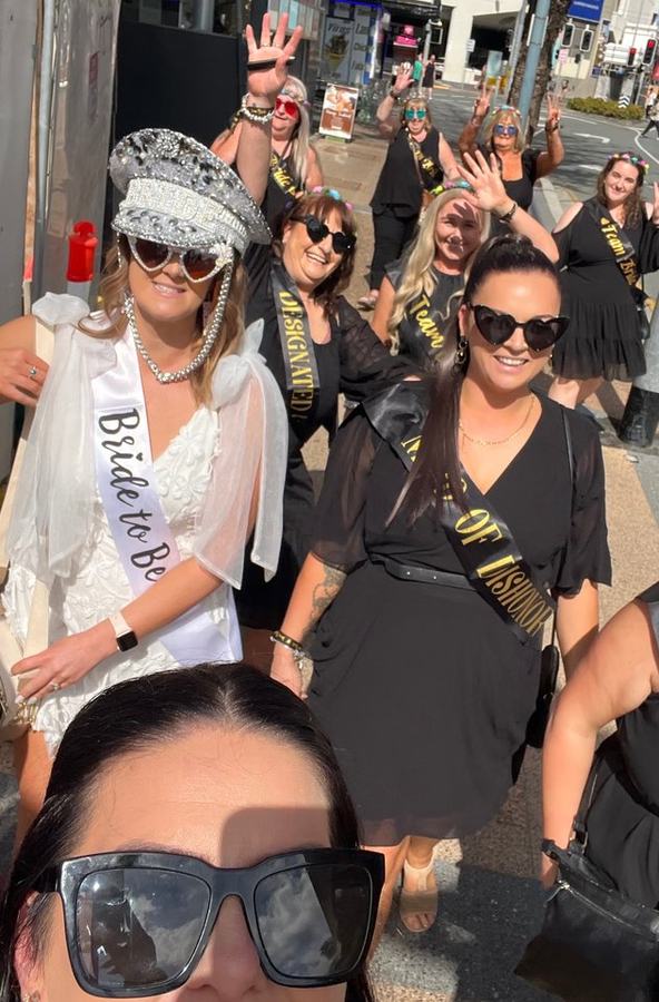 A bride to be in a crown walking with her group