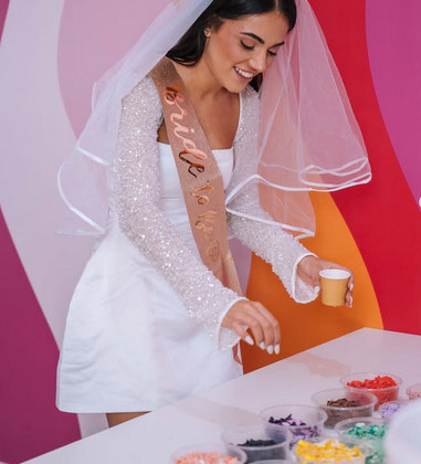 A bride to be in a veil and sash at an art and craft class