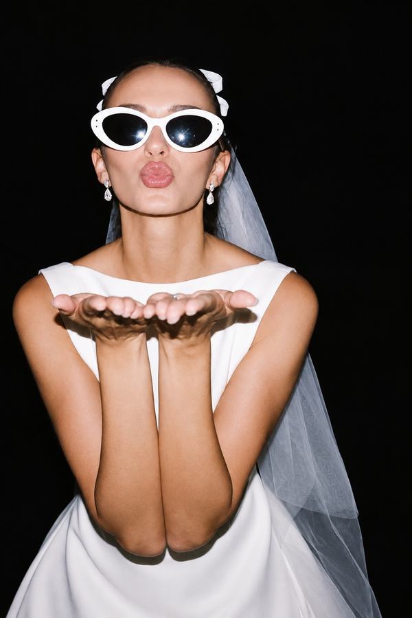 A bride to be in a veil blowing a kiss