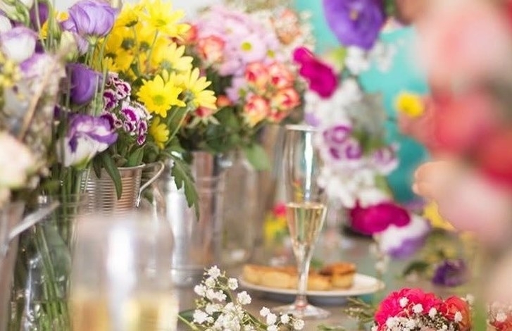 Bright fresh flowers and a glass of bubbly on the crown making table