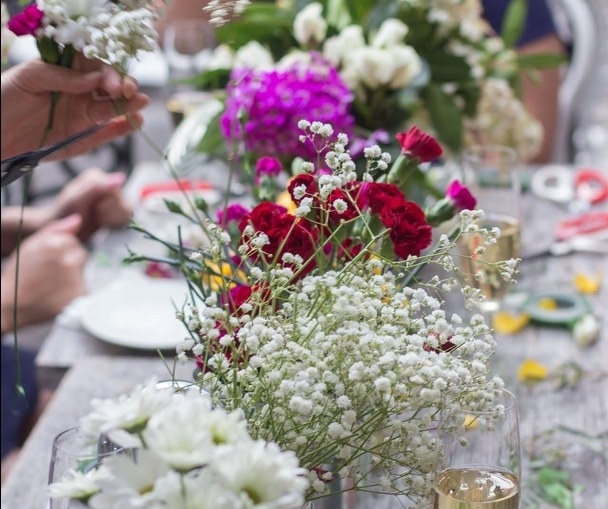 Fresh flowers and glasses of bubbly on the crown making table