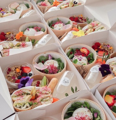 Individual grazing boxes with salads, pastries and edible flowers