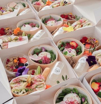 Individual grazing boxes with salads, pastries and edible flowers