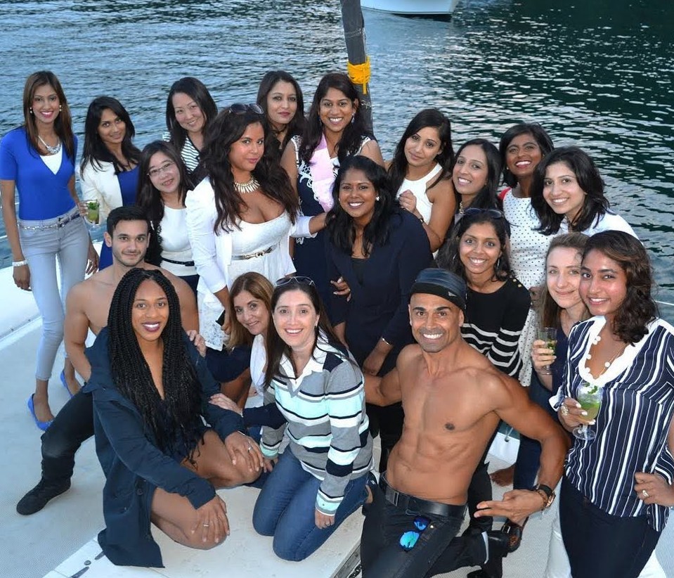 A big hens crew on a catamaran at dusk with two of our topless waiters