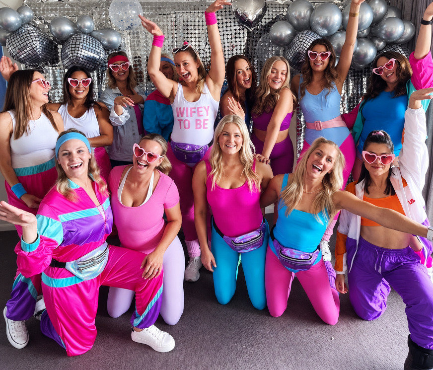The same hens group up close in shell suits, sweatbands and heart sunglasses, one in a WIFEY TO BE top