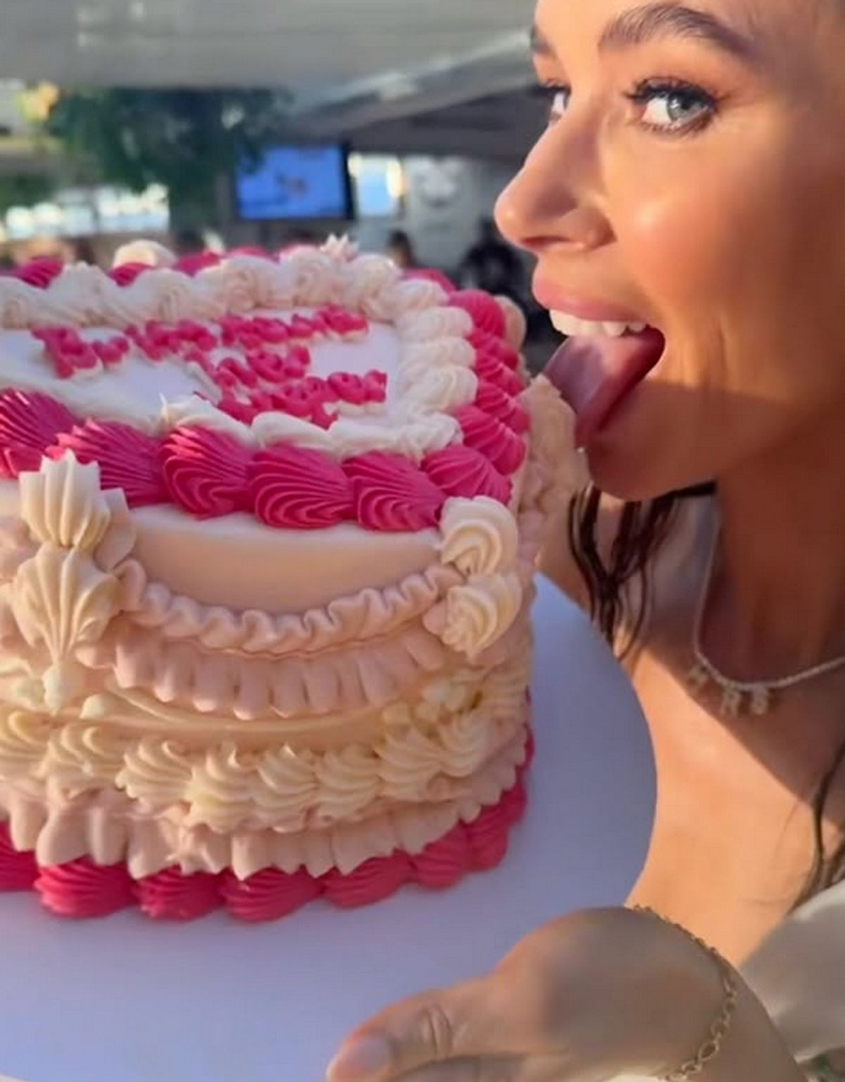 A hen tasting the icing on a pink and white heart cake