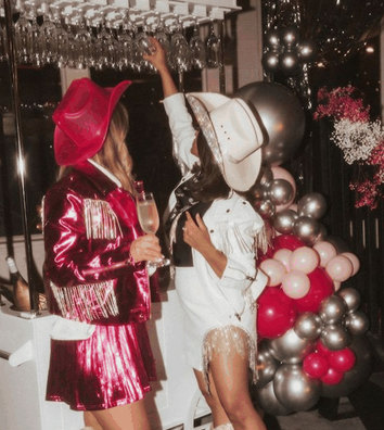 Two friends in pink sequins and cowboy hats at a hens party