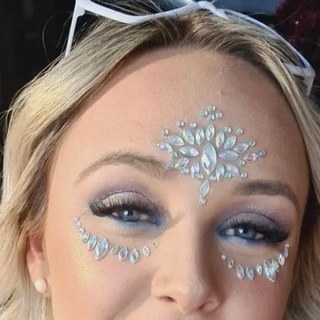 A woman with silver face gems across her forehead and cheekbones