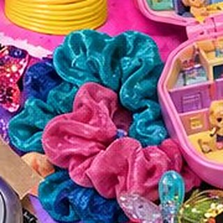 A pile of velvet scrunchies in hot pink and teal