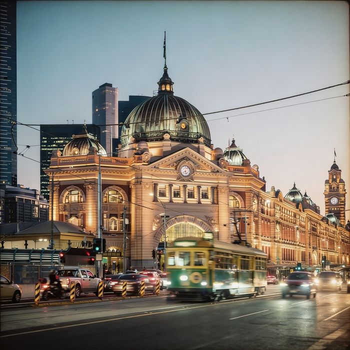 Flinders Street Station at dusk with a tram passing