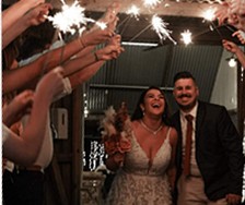 Britt and her husband on their wedding day, walking out under a tunnel of sparklers