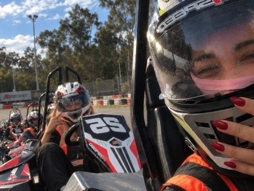 A helmeted selfie from a kart on the karting grid, with the girls lined up in karts behind