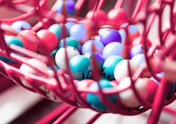 Vibrant bingo balls placed inside a red cage ready to play