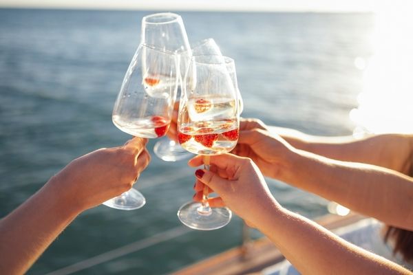 Glasses of bubbles held up against a perfect ocean