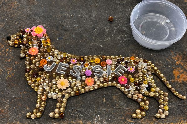 Glass bead mosaic of a dachshund with the name JESSIE spelt in silver letters