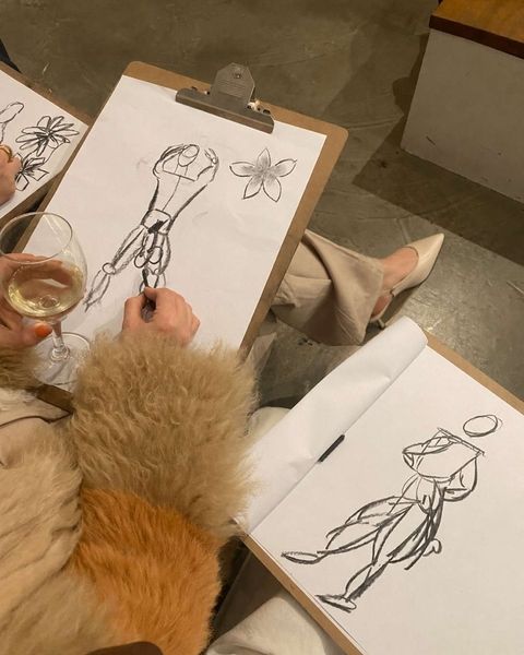 Life drawing sketches on clipboards with a glass of wine