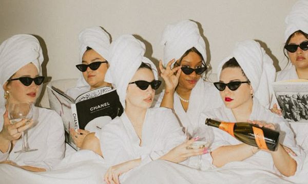 Friends in robes, towels and sunglasses pouring bubbles