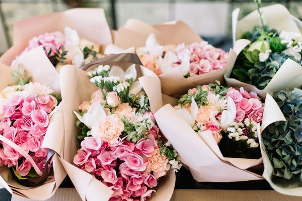 Bouquets of fresh flowers are laid in a brown table to be used in flower crown making workshop