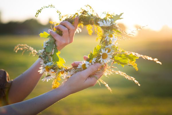 A gorgeous hen is holding a beautiful flower crown she made herself during the workshop