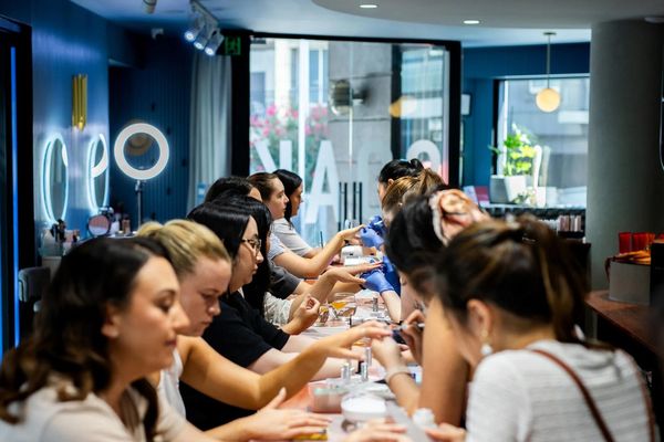 A long row of women having their nails done at a busy nail bar