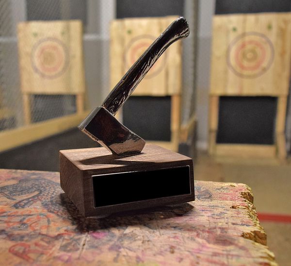 An axe was lodged in a brown wooden block ready to be thrown