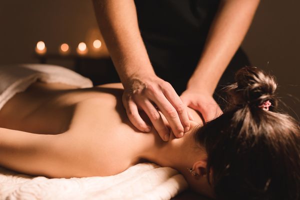 A woman relaxing during a candlelit back massage