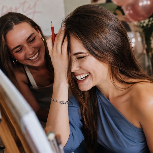 Two friends laughing together at a life drawing class