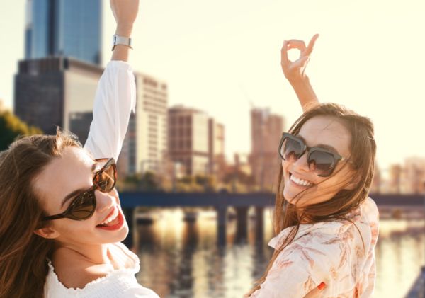 Two charming women enjoyed the private cruise and river view while taking a picture with a peace sign on a front deck