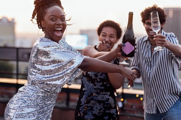 Three lovely friends raise a toast and have fun together on the rooftop bar