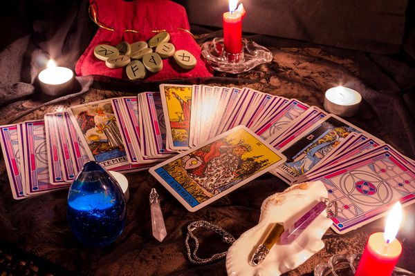 Tarot cards fanned across a table by candlelight