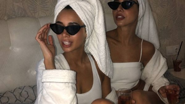 Two friends in white robes, towel turbans and sunglasses