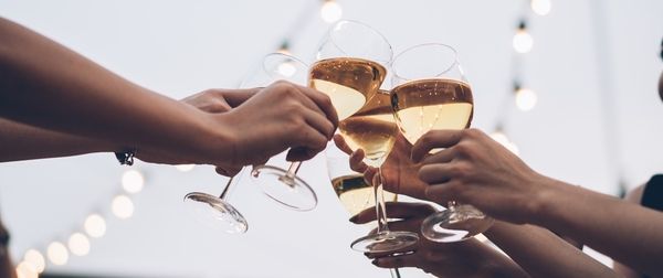 group of women's hands clinking together bubbly in glass flutes