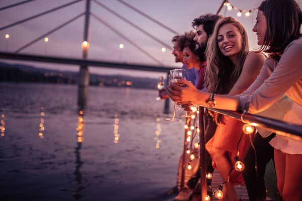 Ladies overlooking a sunset river with a glass of bubbles