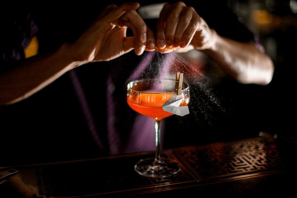 Cocktail making class with orange cocktail and paper crane garnish