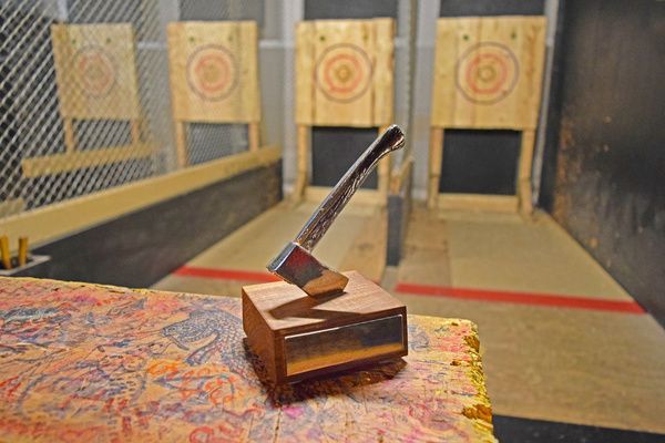 An axe was lodged in a brown wooden block ready to be thrown