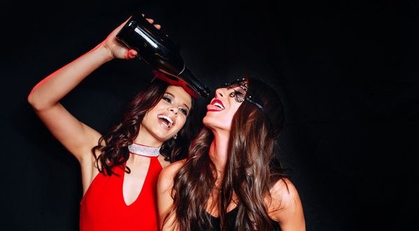 Two lovely ladies are wearing red and black dresses and having fun in a private room