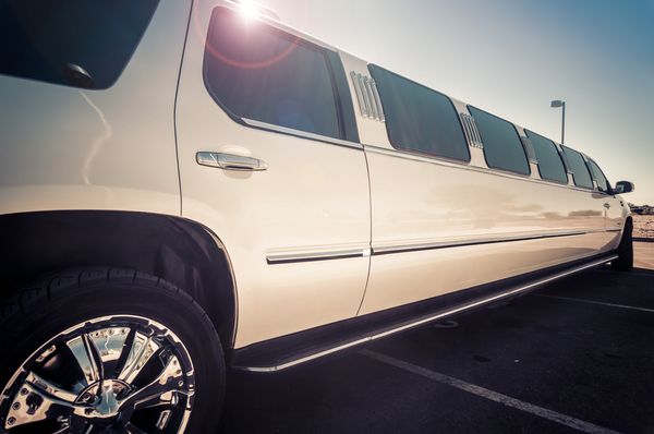 A white stretch limousine parked in the sun