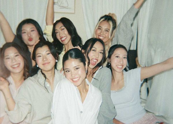 Friends in pyjamas cheering and smiling together, arms in the air