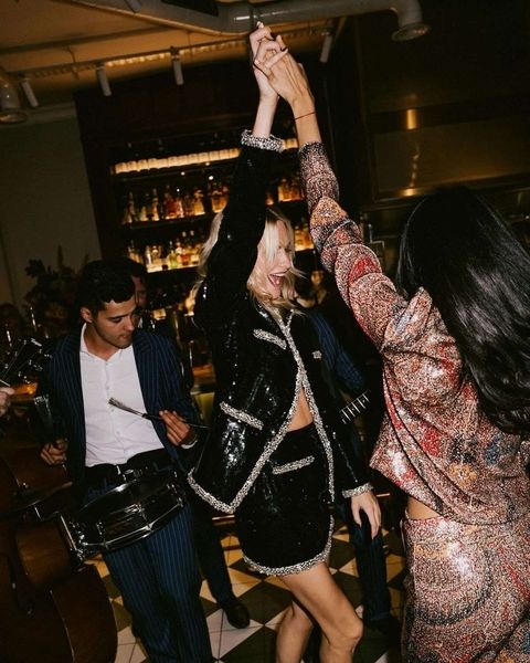 Friends dancing and raising their arms in a bar