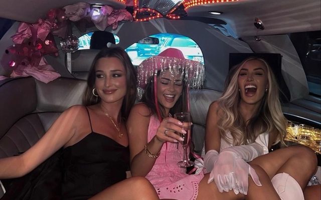Friends laughing together inside a limo lit with coloured lights