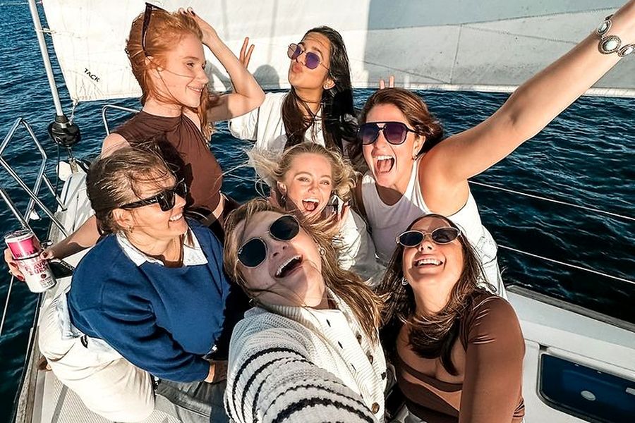 Friends squeezed into a selfie on the deck of a yacht