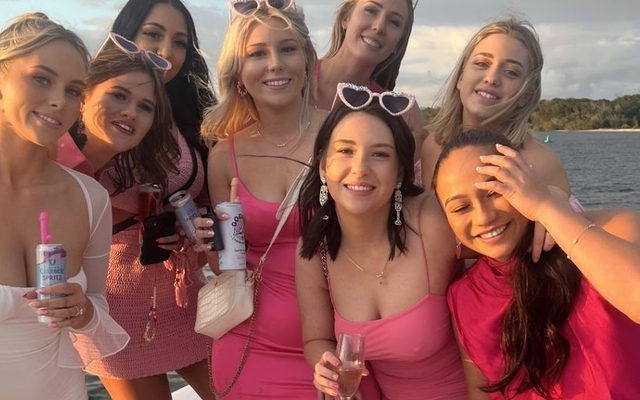 A hens group in pink and white crowding together on a boat deck