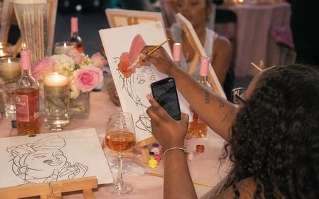 A hens life drawing table mid-class, with sketches, drinks and candles