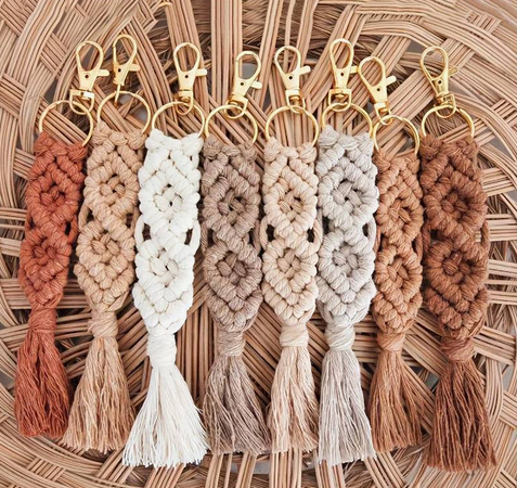 Macrame keyrings in pink, cream and rust laid on a woven tray