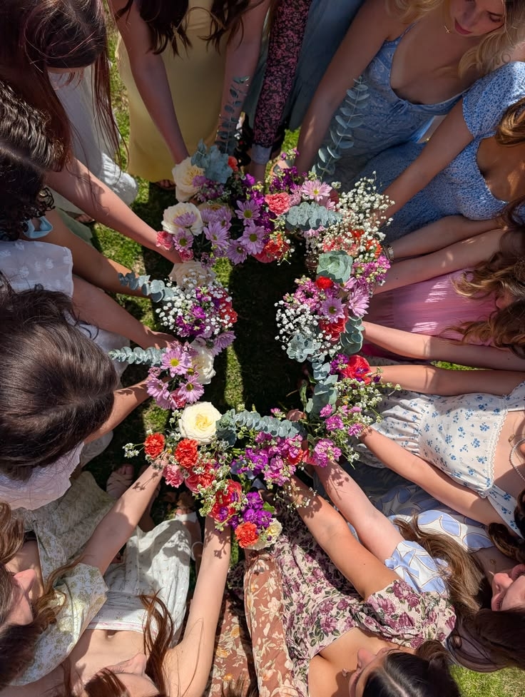Looking down on a circle of friends holding colourful flower bouquets