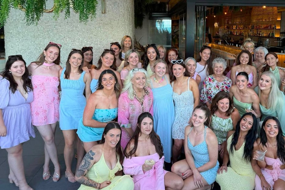 A big hens group of all ages in pastel dresses gathered together outside