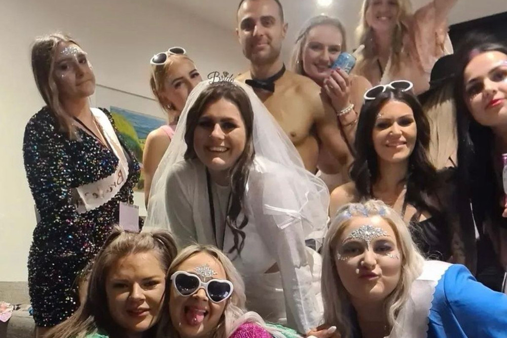 Hens in heart sunglasses around the bride in a veil at a Barbie hens
