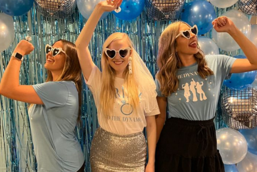 Three hens in heart sunglasses dancing in front of blue tinsel and disco balloons