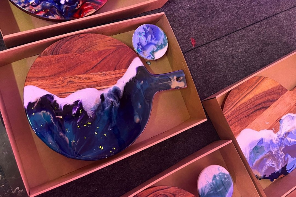 Finished resin cheeseboards in swirled blues and white, packed in gift boxes